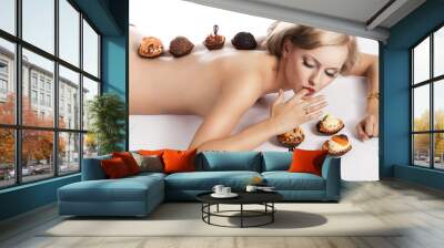 blond sexy girl eating pastry, she has one finger in mouth Wall mural