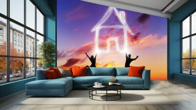 A couple jump and make a house symbol of light. New home Wall mural