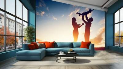 happy family together, parents with their little baby at sunset Wall mural