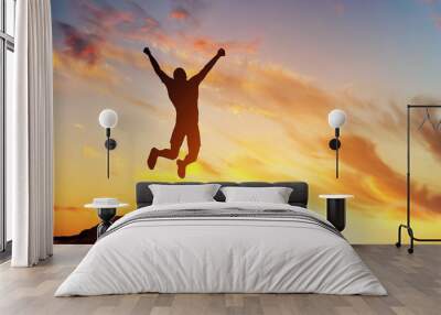 Happy man jumping for joy on the peak of the mountain. Success Wall mural