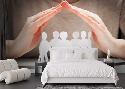 Paper people under hands in gesture of protection.. Concept of insurance Wall mural