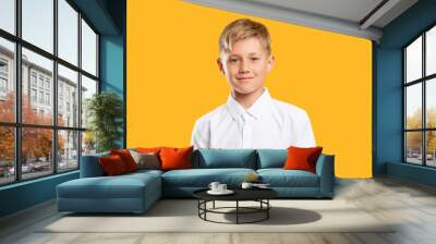 Happy kid portrait. Back to school. Confident blond boy in white shirt smiling isolated on orange background. Wall mural