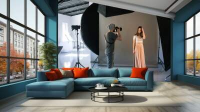 Photographer work in professional studio . Man taking shot of female model. Photo school, lookbook, fashion backstage concept Wall mural