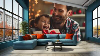 Dad with gift and greeting card congratulates his son at home. Wall mural