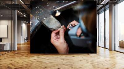 jeweler saws at a gold ring in authentic jewellery workshop Wall mural