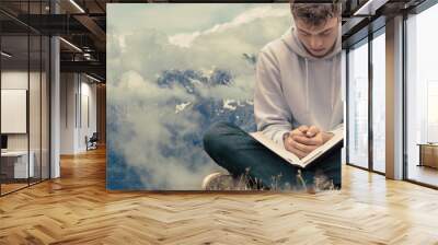 Christian worship and praise. A young man is praying and worshiping in the evening. Wall mural