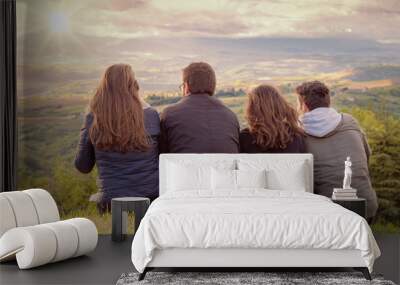 Christian worship and praise. Group of friends hugging outdoors at sunset. Wall mural