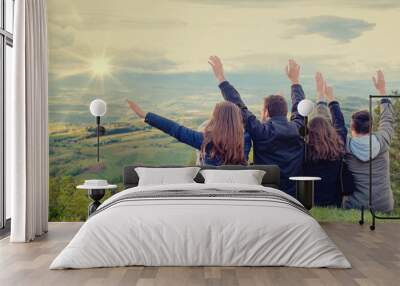 Christian worship and praise. Group of friends hugging outdoors at sunset. Wall mural