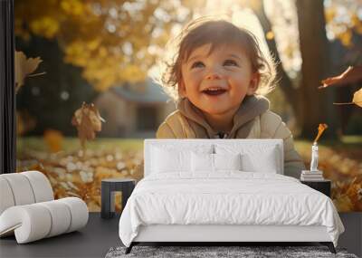 Portrait of young joyful child having fun throwing leaves in autumn. Wall mural