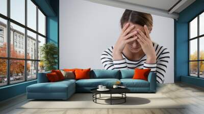 Beautiful young woman suffering from mood disorder and holding her head, photo with copy space Wall mural