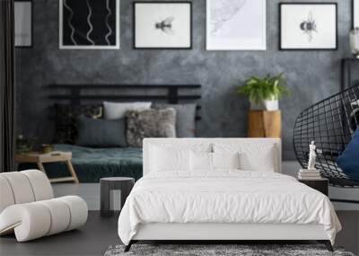 Black diamond chair with blue pillow and open book on end table standing in dark room interior photo with blurred background Wall mural