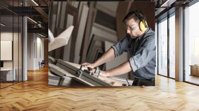 Carpenter cutting wooden plank Wall mural