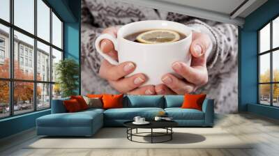 Hands holding a cup of tea Wall mural