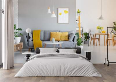 orange blanket on grey sofa in modern apartment interior with poster and wooden table. real photo Wall mural