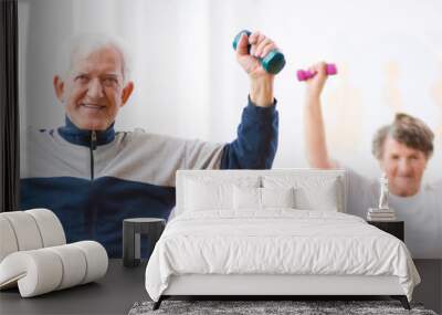 Panorama capture of two senior man and woman working out with weights Wall mural