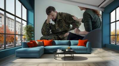 Professional psychiatrist supporting crying soldier with war syndrome in the office Wall mural