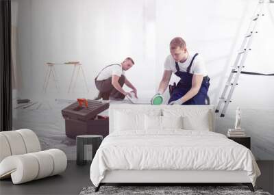 Renovation workers preparing for painting the room and installing a floor Wall mural