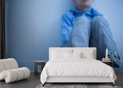 Sad boy sits alone Wall mural