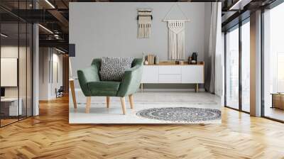 Simple, white and gray living room interior with a sofa between a wooden table and cupboard. Real photo Wall mural