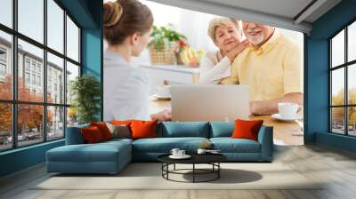 Smiling elderly man and woman purchasing a trip at the travel agency Wall mural