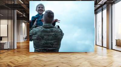 Soldier with his son in his arms Wall mural