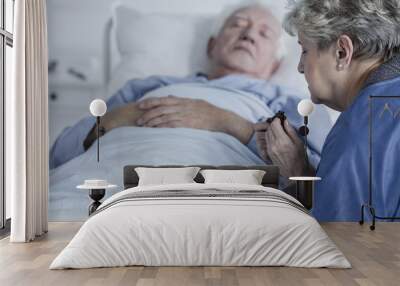 Woman praying for husband's health Wall mural