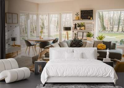 Wooden, round dining table in the corner of an open space living room interior with nordic furniture and decor Wall mural