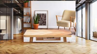 Wooden coffee table in elegant living room interior with vintage armchair, green plant in pot and poster in frame, real photo Wall mural