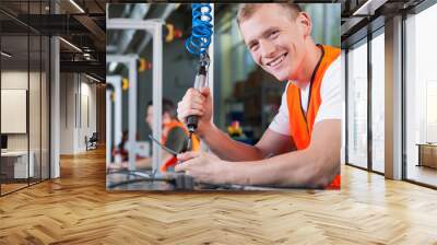 young smiling man working on the production line Wall mural