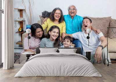 family sitting on sofa and smiling Wall mural