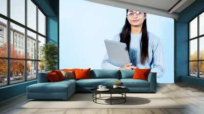 Portrait of young  girl holding laptop Wall mural