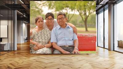 Family portrait of a young Indian woman with her mother and father posing in a park in Delhi, India Wall mural