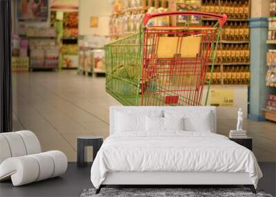 Shopping carts in a modern hypermarket store in a mall. The POS impulse products are clearly visible as people/customers are seen moving in FMCG area of the retail store Wall mural