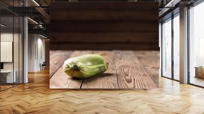 Trendy ugly organic squash on natural wooden table on dark blurred background. Copy space. Wall mural