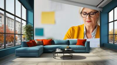 Mature woman reviewing a company's annual report, meticulous and detail-oriented Wall mural