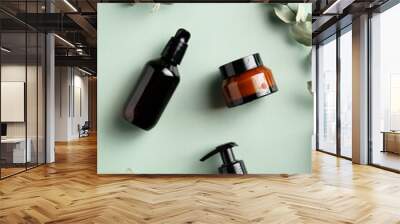 Amber glass cosmetic bottles and eucalyptus leavers on green background top view. SPA natural organic cosmetics set. Skincare concept. Wall mural