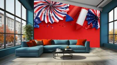 American federal holidays celebration concept. Flat lay composition with festive paper fans and firework rockets on red background. Wall mural