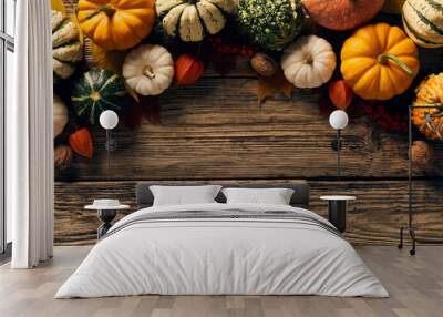 Autumn still life. Flat lay pumpkins, fallen leaves, walnuts, fall decorations on wooden table. Top view with copy space. Wall mural