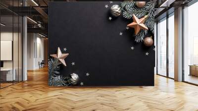 Christmas banner. Christmas tree branches decorated copper color stars and balls on black background. Flat lay, top view. Xmas banner mockup with copy space. Wall mural