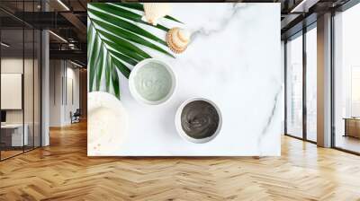 Facial clay mask and tropical leaf on marble background. Flat lay natural organic SPA cosmetic products for skincare, body and hair care concept Wall mural