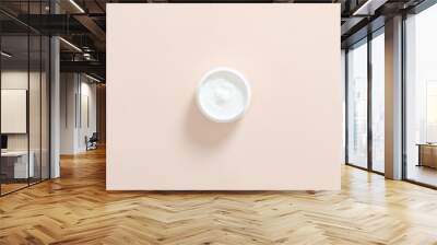 Jar with moisturizing hand cream on pastel pink background. Skin care cosmetic concept. Minimal flat lay style composition, top view, overhead. Wall mural