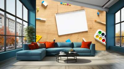 School notebook and various stationery on a wooden desk table. Back to school concept. Flat lay style composition, top view, overhead. Wall mural