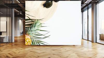 Summer travel vacation concept. Top view female straw beach hat, sunglasses, pineapple, palm leaf on white background Wall mural