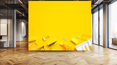 Vibrant yellow background with neatly organized office supplies including pencils, pens, notepad, ruler and paper clips. Perfect for educational themes or creative project concepts Wall mural