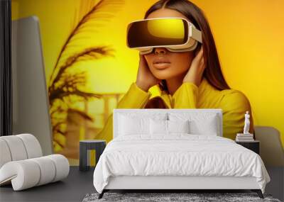 Fashion woman wearing a virtual reality headset, in modern yellow colored interior. She is sitting at the computer, lightly touching her face with hand. Innovative technology concept Wall mural