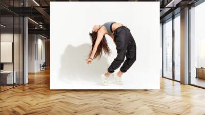 Agile supple young woman doing a modern hip hop dance pose Wall mural