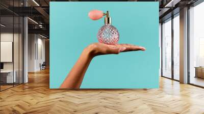 Black female hand showing classic perfume bottle Wall mural