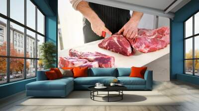 Butcher or cook slicing chuck steaks Wall mural