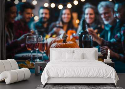 Festive Halloween Dinner Party With Friends Toasting Around A Pumpkin Centerpiece Under String Lights, Drinks, Pumpkin And Fall Leaves On Table Wall mural