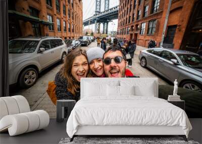 happy friends tourist taking selfie in Manhattan Bridge seen from Dumbo, Brooklyn, New York City, USA Wall mural